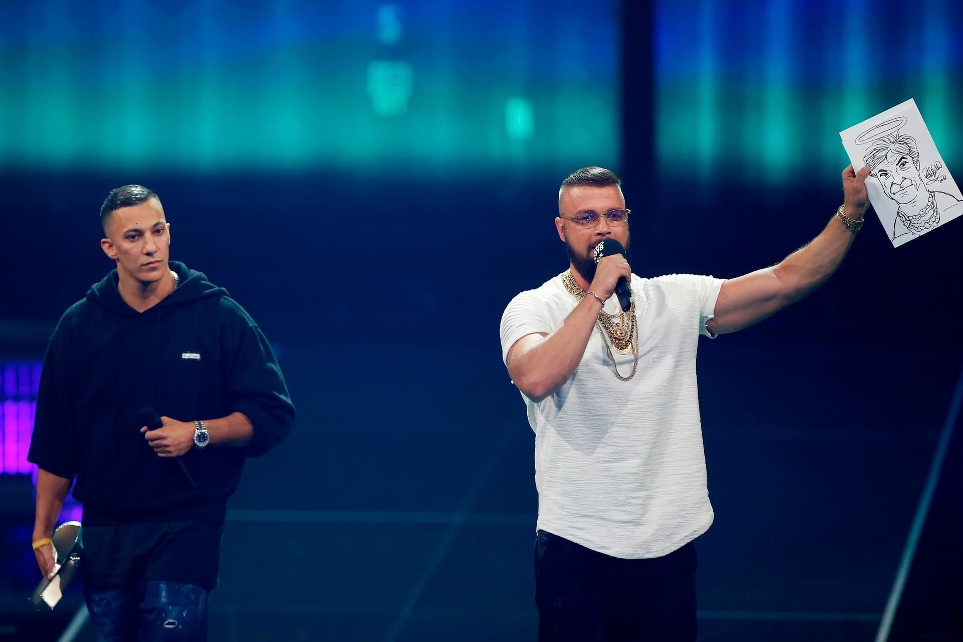 Die Rapper Kollegah (r) und Farid Bang auf der Bühne beim Echo. Die Rapper halten eine Karrikatur von Sänger Campino mit Heiligenschein hoch.