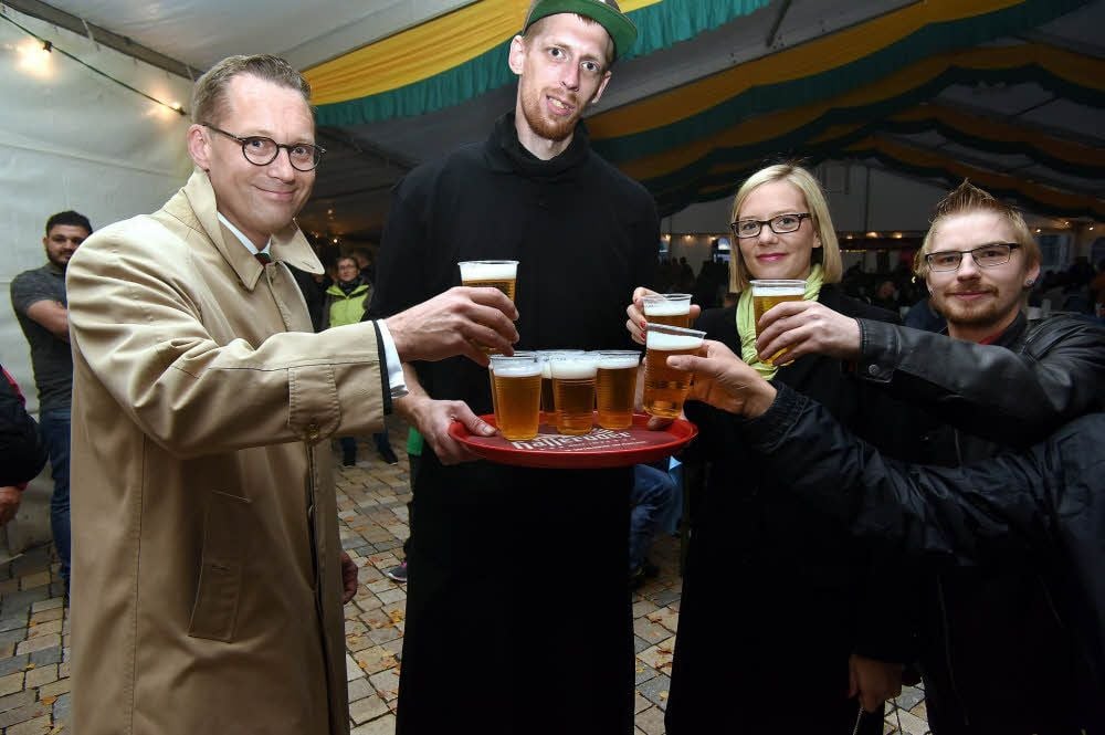 Oberbürgermeister Christian Thieme (li.) und seine Frau Louisa greifen bei Erik Fionzek zu und stoßen mit Zeitzern auf das Zuckerfest an.