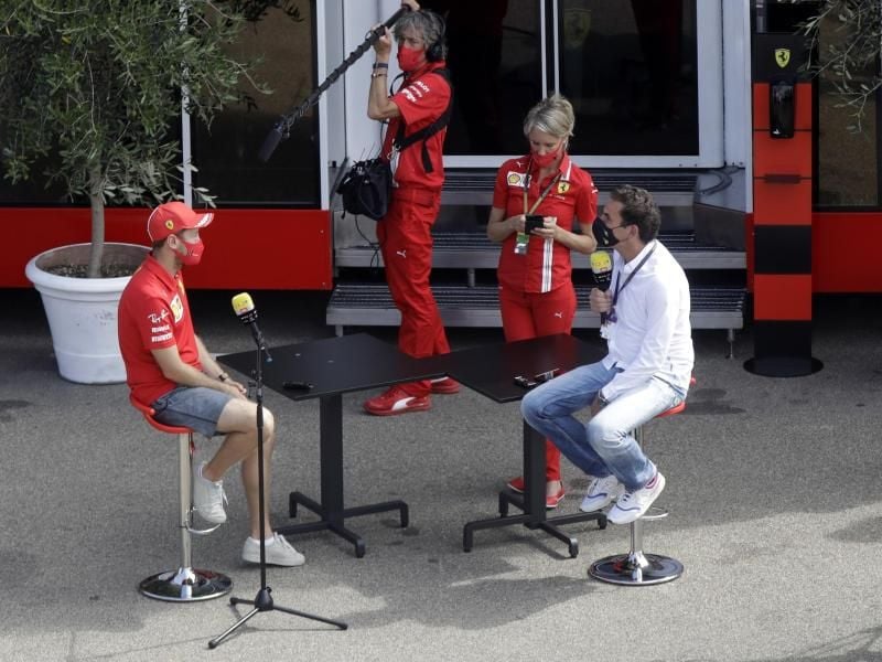 Sebastian Vettel (l) von der Scuderia Ferrari wird auf der Rennstrecke von Mugello interviewt. Foto: Luca Bruno/AP/dpa
