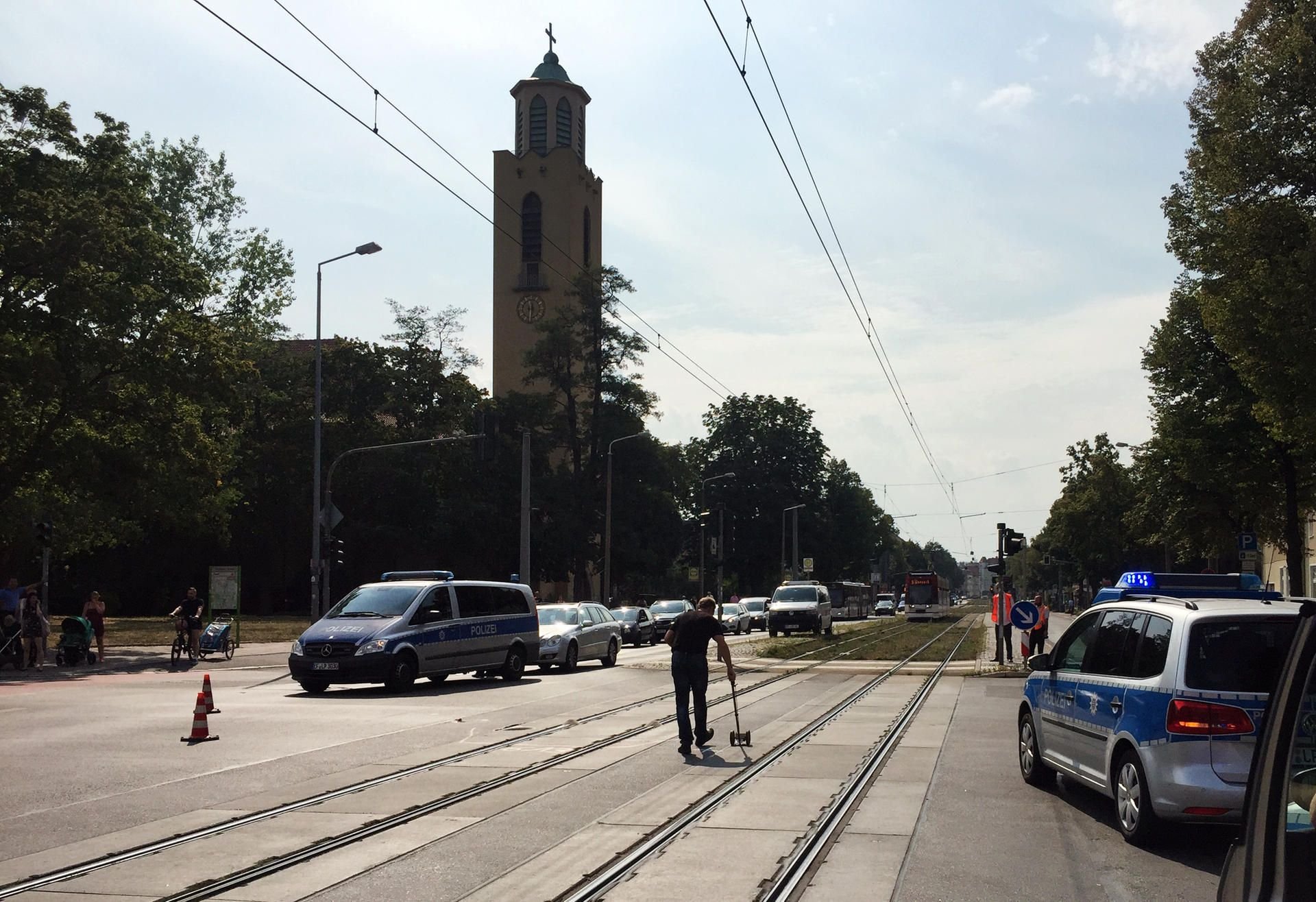 Polizisten untersuchen eine Unfallstelle. Eine 78-Jährige wurde in Erfurt von einer Straßenbahn erfasst und lebensgefährlich verletzt.