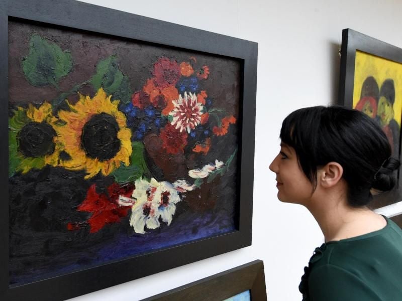 Caroline Dieterich, Mitarbeiterin der Nolde Stiftung, blickt auf ein Gemälde. Foto: C. Rehder/Archiv