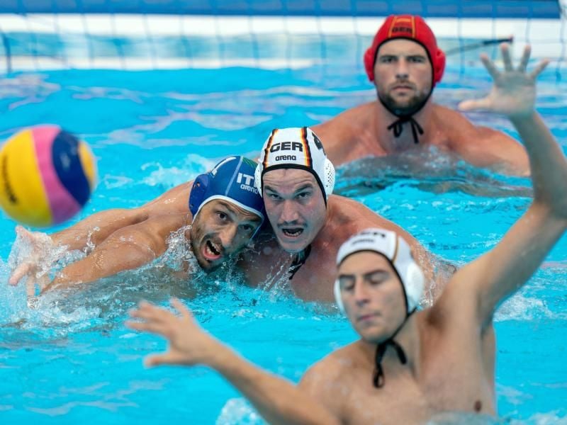 Julian Real (M) und Matteo Aicardi (l) von Italien versuchen, an den Ball zu kommen. Hinten Deutschlands Torhüter Moritz Schenkel. Foto: Bernd Thissen