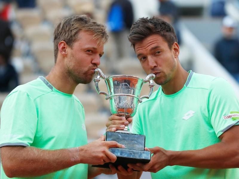 Kevin Krawietz (l) und Andreas Mies feiern ihren historischen Doppelsieg in Paris. Foto: Pavel Golovkin/AP