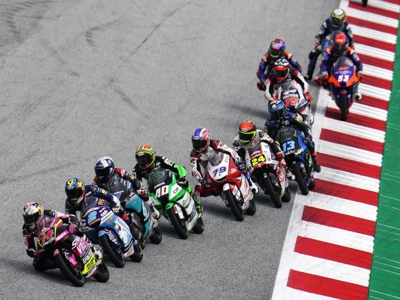 Moto3-Piloten lenken ihre Motorräder nach dem Start in Spielberg in eine Kurve. Foto: Steve Wobser/AP/dpa