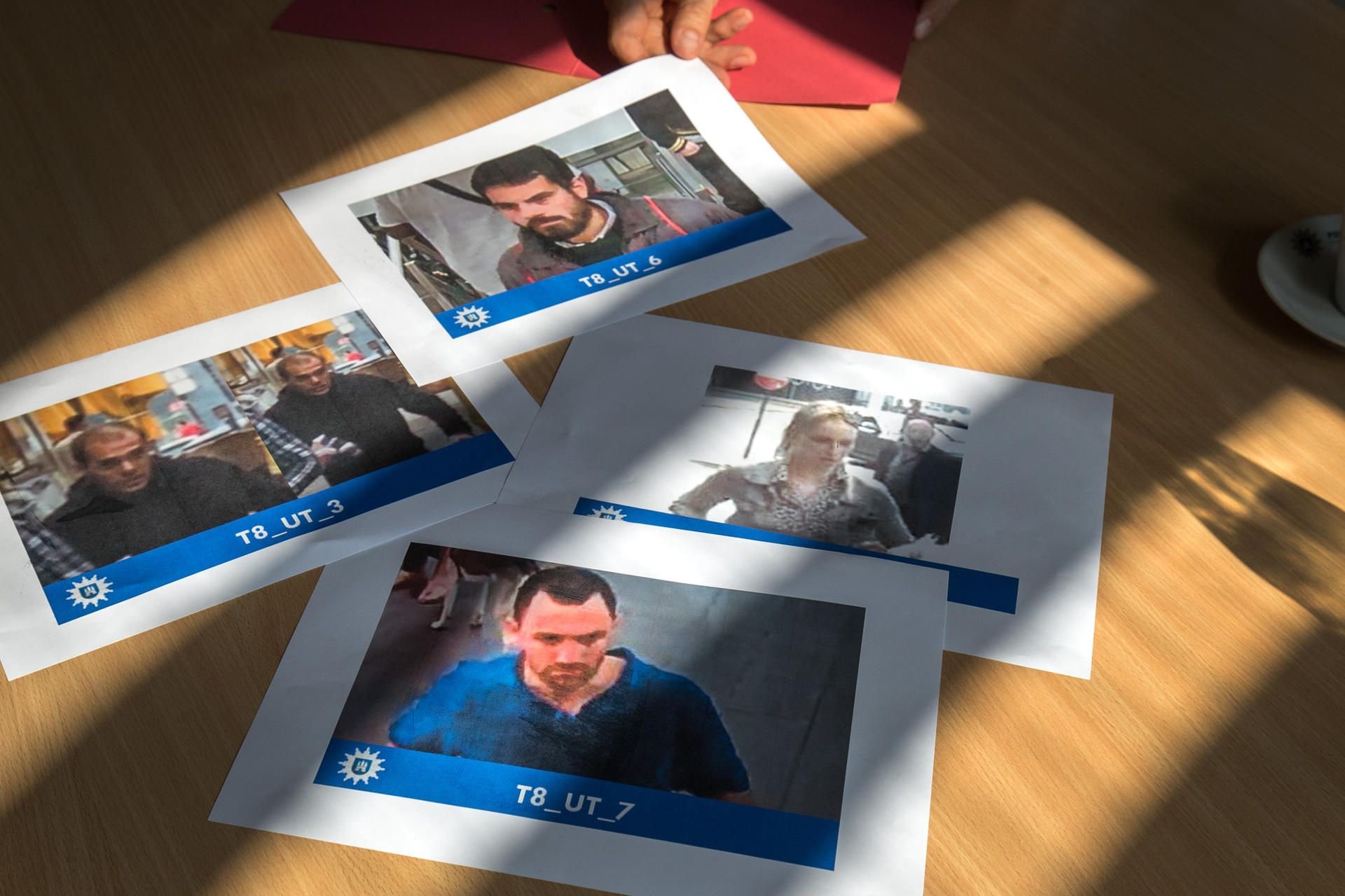 Ausdrucke von Fahndungsfotos liegen auf einem Tisch im Polizeipräsidium. Die Hamburger Polizei hat erstmals eine europaweite öffentliche Fahndung nach vier mutmaßlichen Gewalttätern gestartet.