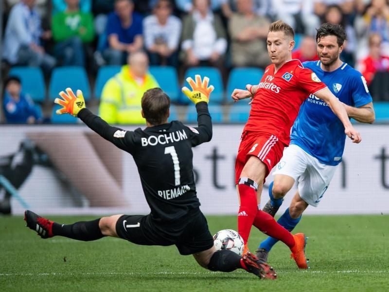 Bochum-Keeper Manuel Riemann (l) schmeißt sich HSV-Profi Lewis Holtby in den Weg. Foto: Guido Kirchner/dpa