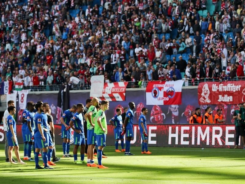 Nach der Niederlage in Leipzig stehen die Wolfsburger Spieler deprimiert vor ihren aufgebrachten Fans. Foto: Jan Woitas