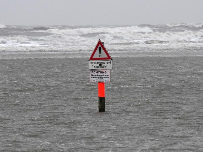 Ein Warnschild steht am Nordseestrand im Wasser. Foto: Carsten Rehder