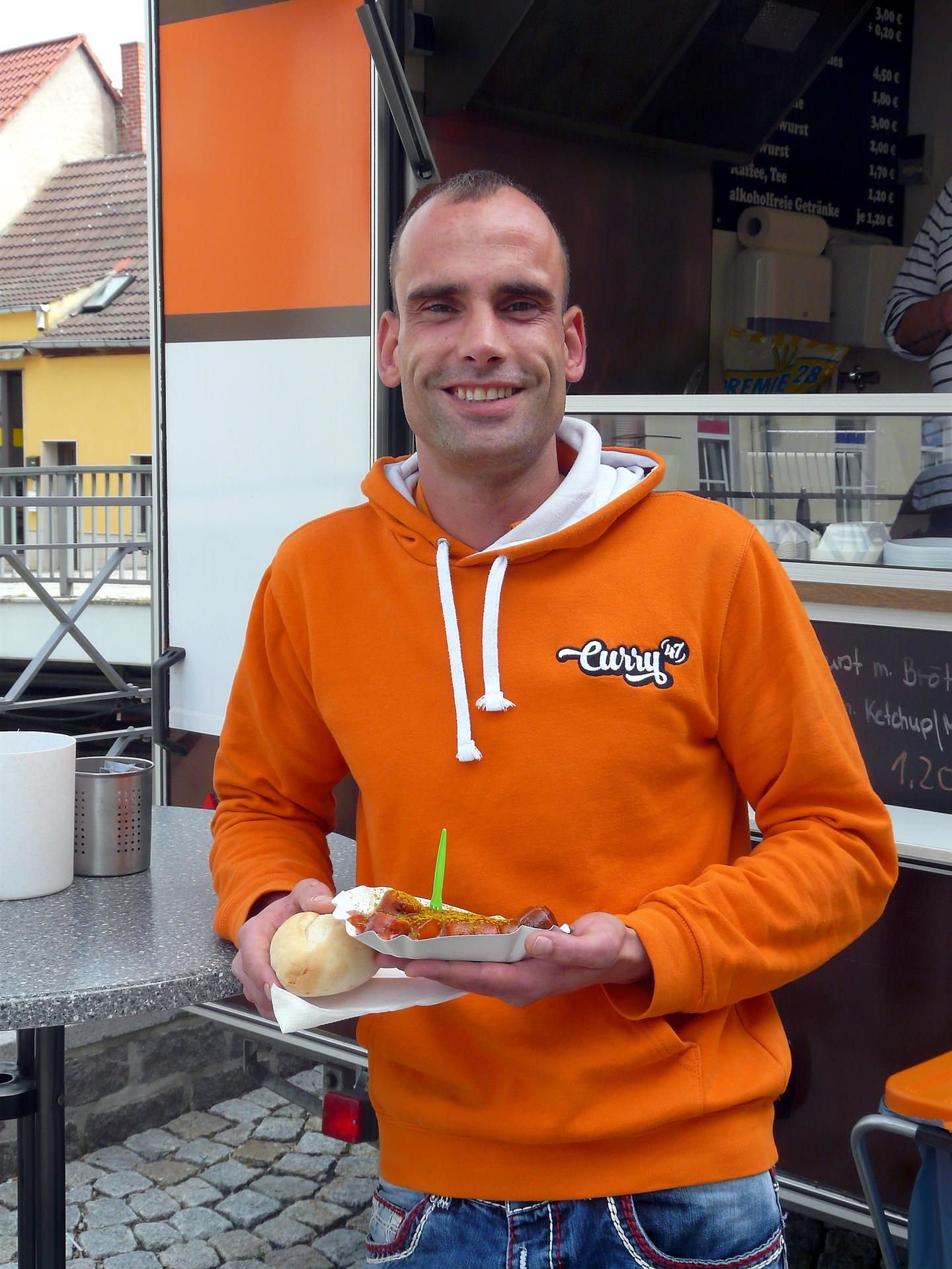 Robert Wenzel mit einer seiner Currywürste - an der Sangerhäuser Roseninsel verkauft er in seinem Imbisswagen Currywürste in unterschiedlichen Schärfegraden.