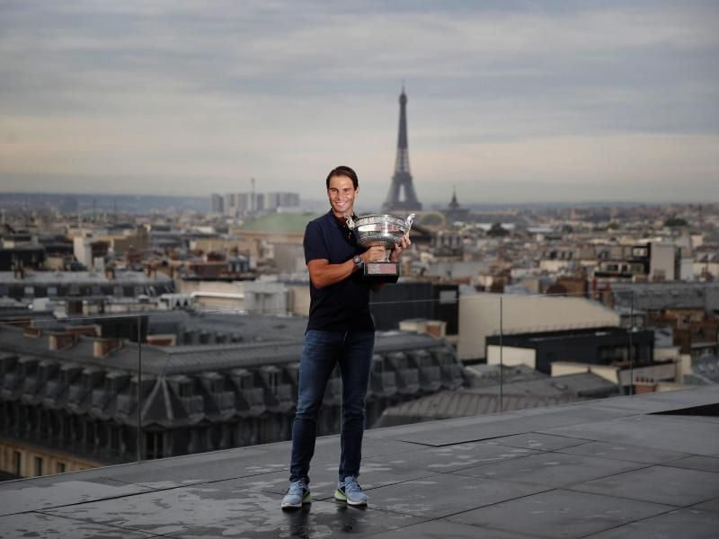 French-Open-Sieger Rafael Nadal posiert mit dem Siegerpokal vor der Kulisse von Paris auf dem Dach der Galeries Lafayette. Foto: Francois Mori/AP/dpa