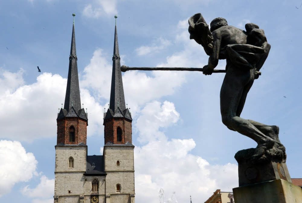 Die Fischerstecher-Figur des Göbelbrunnens weist genau auf den am stärksten aus dem Lot geratenen Blauen Turm der Marktkirche.