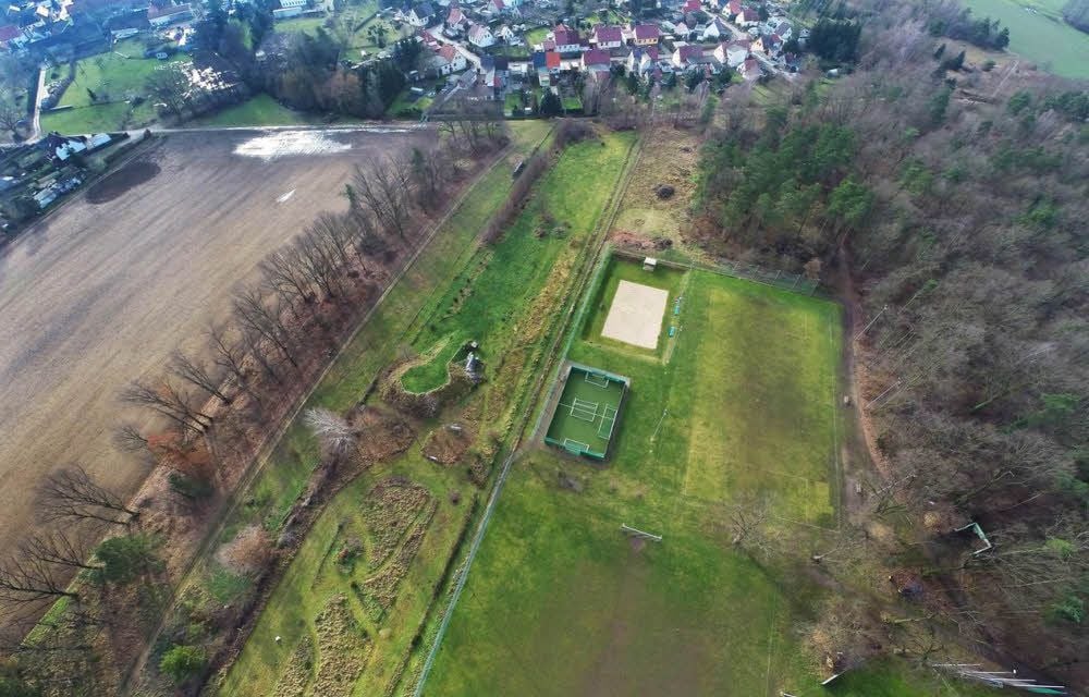Das Grundstück befindet sich links neben dem Sportplatz.