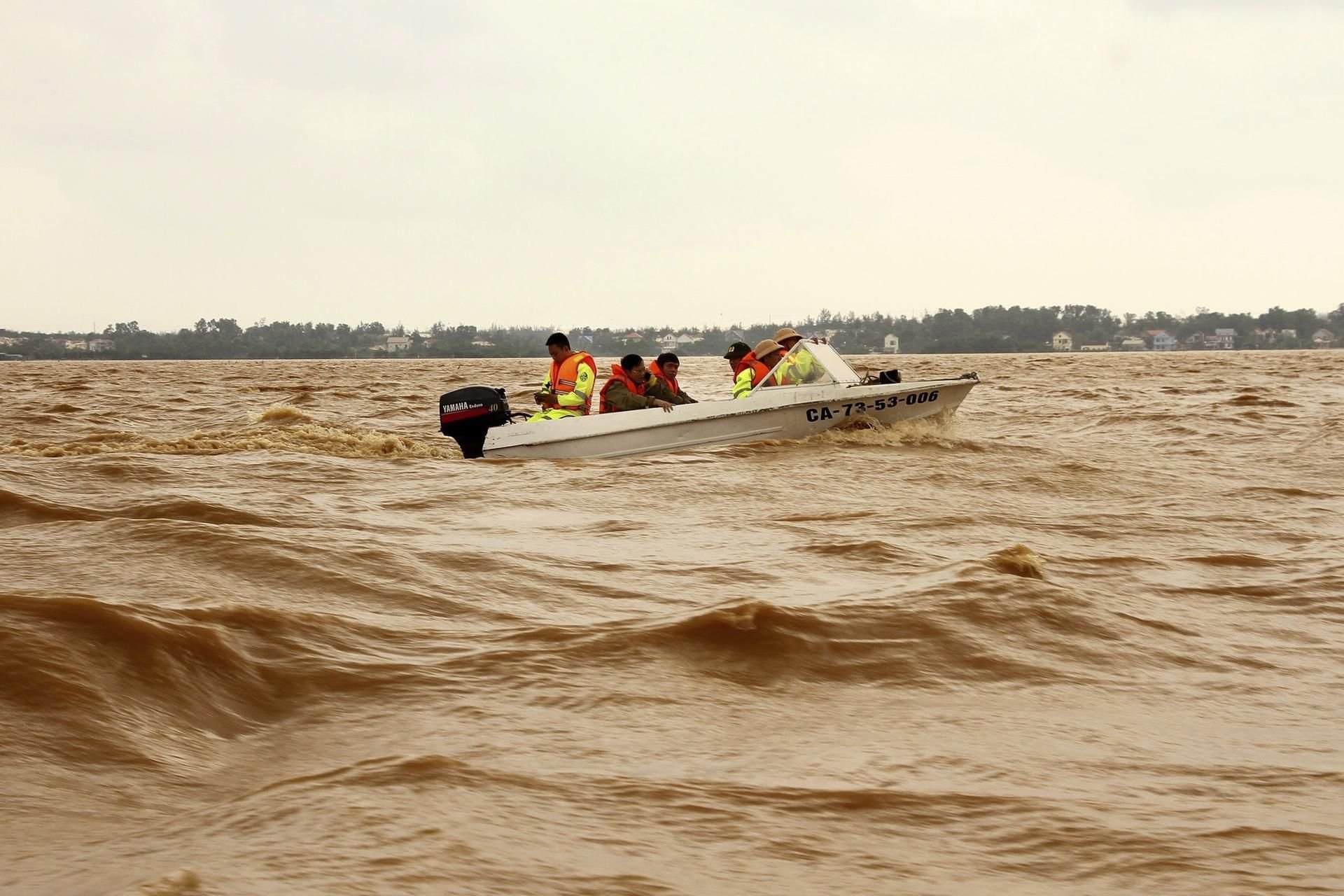 Rettungskräfte fahren mit einem Boot über überflutetes Gebiet.