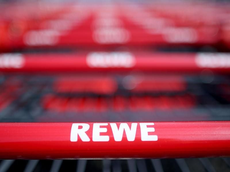Einkaufswagen stehen vor einem Rewe Supermarkt. Foto: Oliver Berg/Archiv