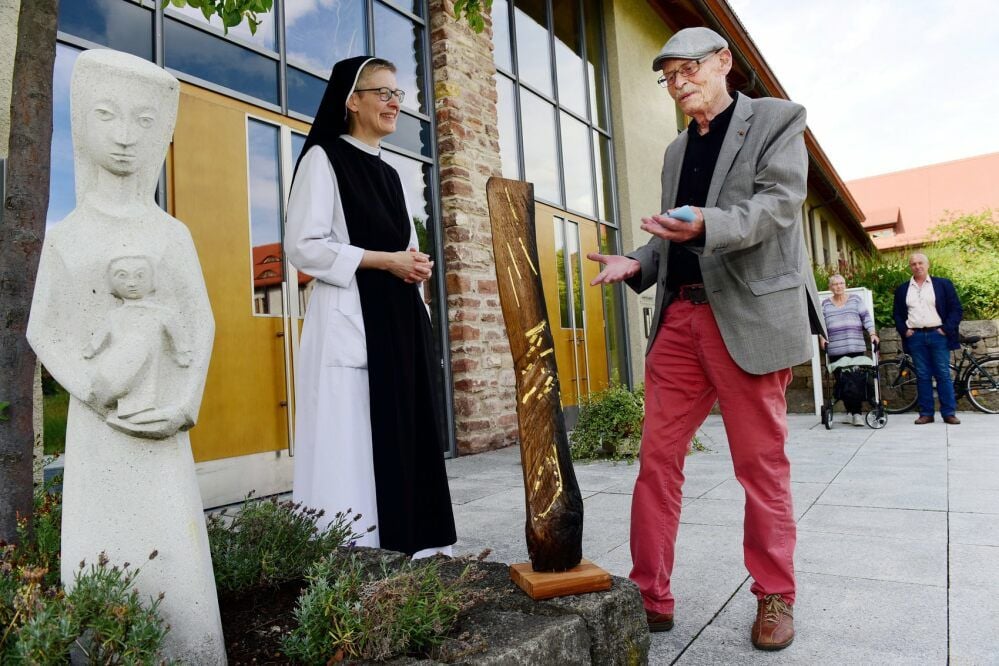 Künstler Martin Hoffmann (re.) überreicht die Holzskulptur an Schwester Christiane Hansen, Priorin im Kloster Helfta.