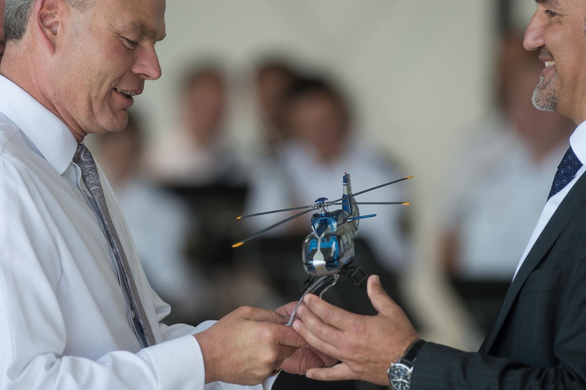 Sachsen-Anhalts Innenminister Holger Stahlknecht (l, CDU) nimmt im Hangar der Polizeihubschrauberstaffel ein Model des neuen Polizeihubschraubers vom Vertriebsleiter von Airbus Helicopters, Thomas Hein (r) entgegen.