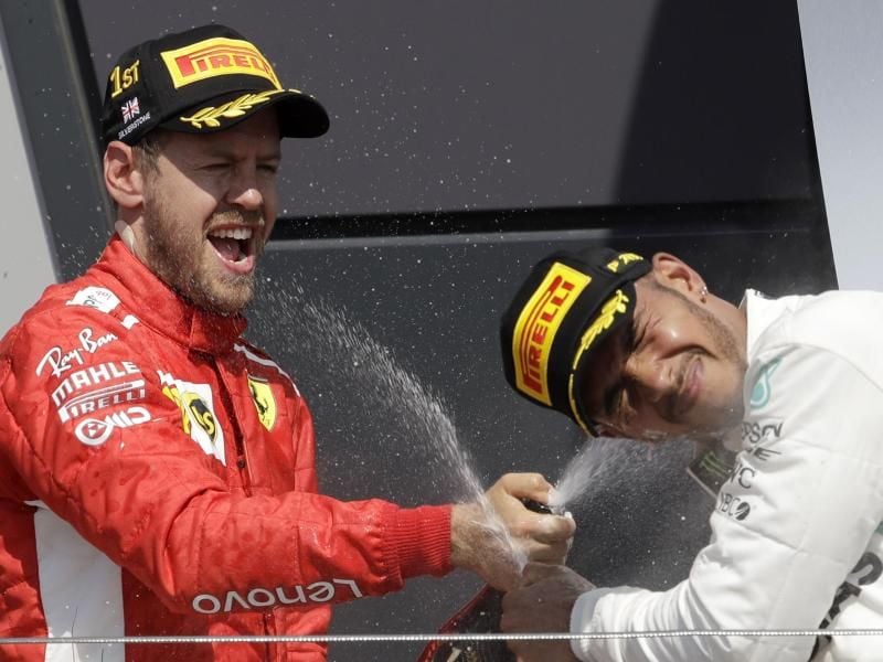 Sebastian Vettel (l) feiert seinen Sieg vor dem Briten Lewis Hamilton. Foto: Luca Bruno/AP