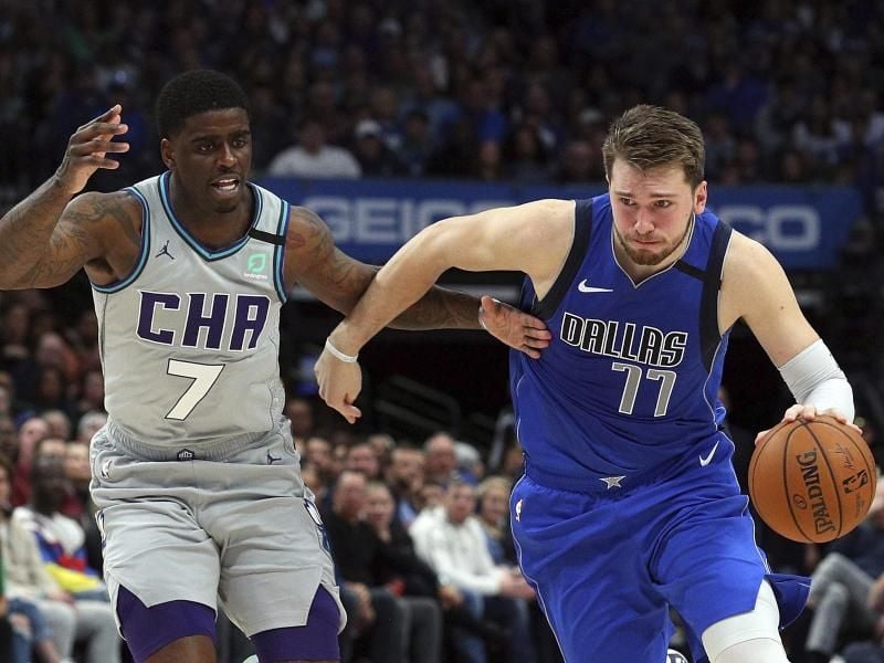 Dwayne Bacon (7/l) von den Charlotte Hornets attackiert Mavs-Spieler Luka Doncic (77). Foto: Richard W. Rodriguez/FR170526 AP/dpa
