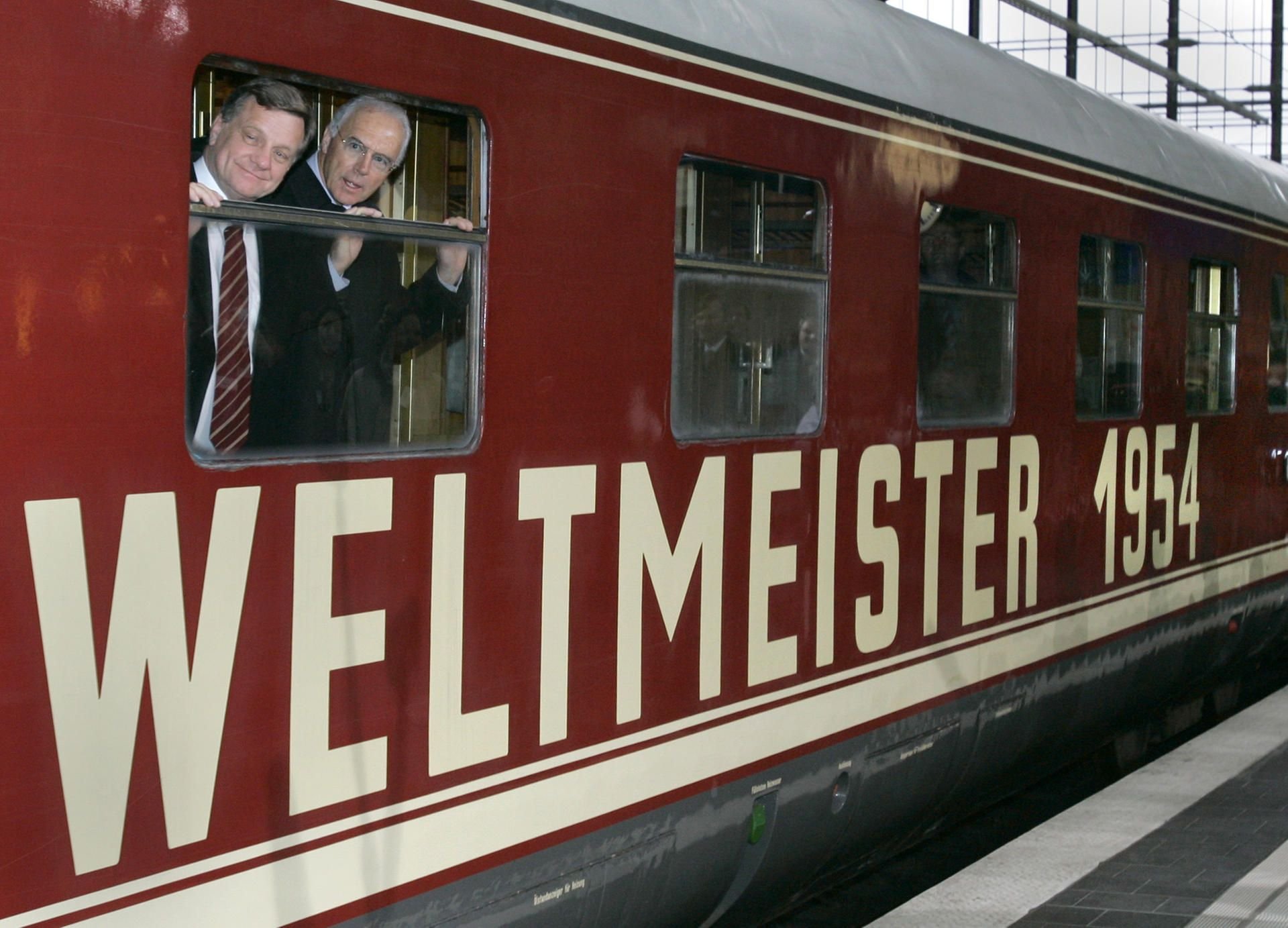 Der damalige Vorstandsvorsitzende der Deutschen Bahn AG, Hartmut Mehdorn (l), und der damalige Präsident des Organisationskomitees FIFA WM 2006, Franz Beckenbauer, schauen aus dem damals als Original-Weltmeisterzug aus dem Jahr 1954 deklarierten Zug.