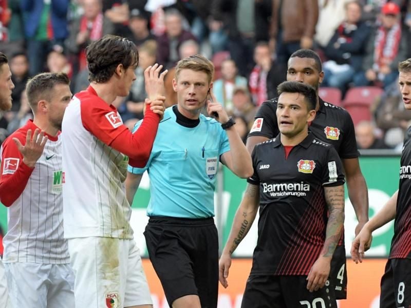 Schiedsrichter Christian Dingert (M) fällt nach einer strittigen Szene eine Entscheidung. Foto: Stefan Puchner