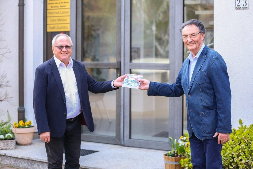 Dr. Bernhard Peitz (rechts), einer der Herausgeber, übergibt das neue Buch „Querfurter Stadtgeschichte Teil II“ symbolisch an Hartmut Lasse, den amtierenden Vorsitzenden des Altertums- und Verkehrsvereins Querfurt und Umgebung.