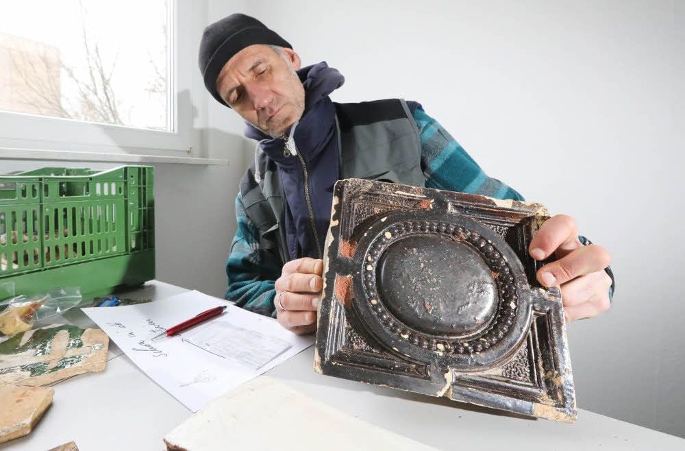Grabungsleiter Ulf Petzschmann mit einigen der Funde. Kacheln und Fliesen weisen auf die serienmäßige Produktion von Gebrauchskeramik hin.
