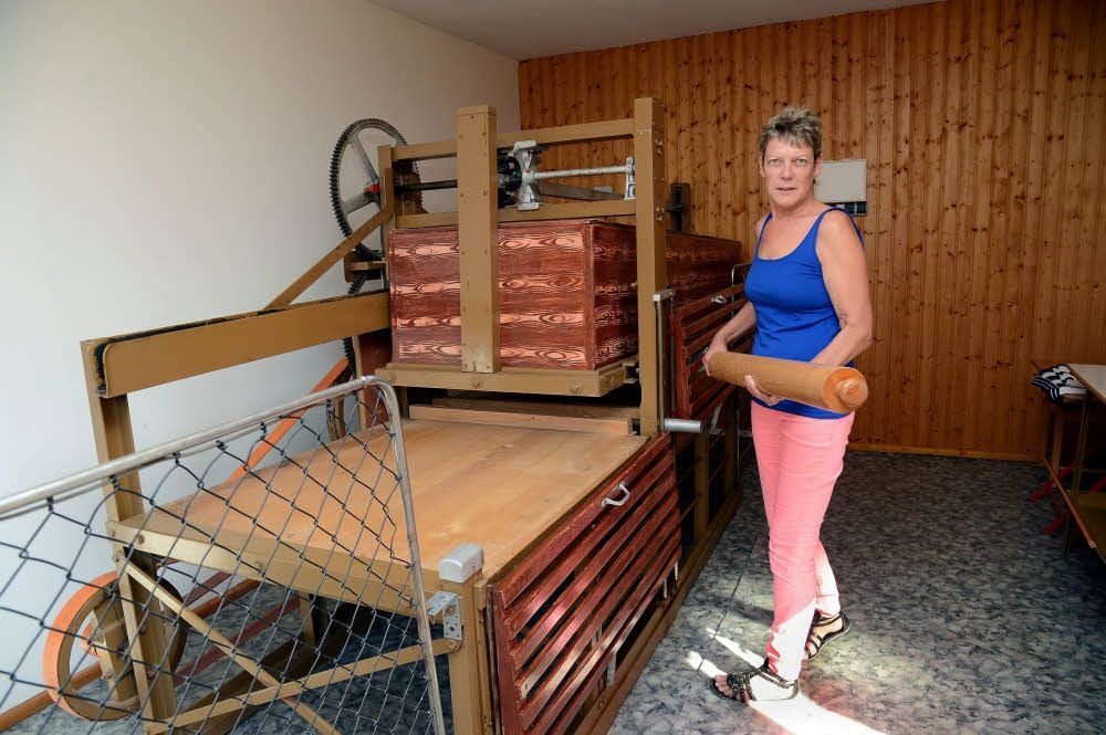 Christiane Hansen bedient die alte Wäschemangel in Wetterzeube.