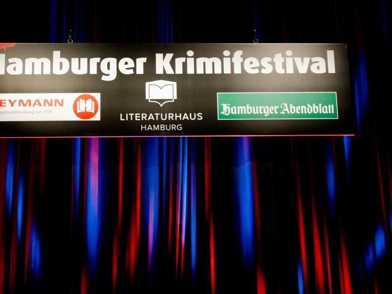Ein angeleuchtetes Schild "Hamburger Krimifestival" hängt in Hamburg. Foto: Daniel Bockwoldt/Archiv