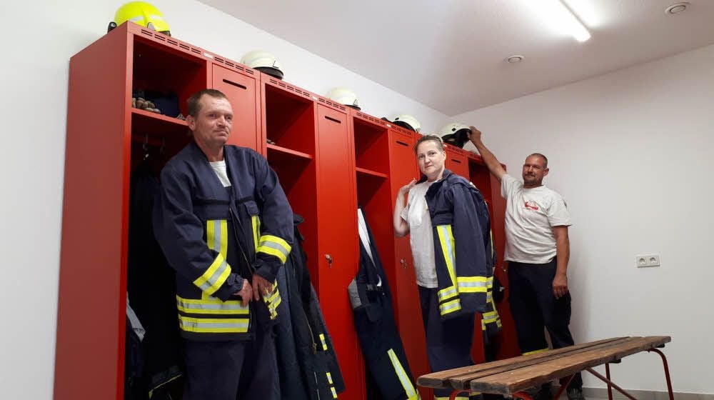 Torsten Bundy, Sabine Burkert und Veit Burkert (v.li.) sind glücklich mit ihrem neuen Feuerwehrgerätehaus in Harkerode. Die Umkleideräume sind größer geworden. Die Frauen haben einen eigenen Umkleide- und Sanitärbereich bekommen.