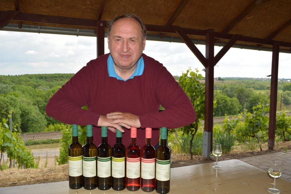 Winzer Helmut Kühn mit den Weinen vom Herzogsberg. Die Etiketten zeigen die Kirche Kriechau.