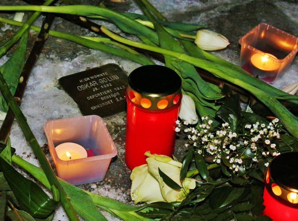 Blumen und Kerzen des Gedenkens schmücken den gerade erst verlegten Stolperstein für Oskar Golub.