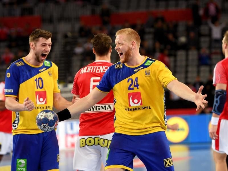 Schwedens Jim Gottfridsson (M) und Niclas Ekeberg jubeln nach Spielende über den Halbfinalsieg über Dänemark. Foto: Monika Skolimowska