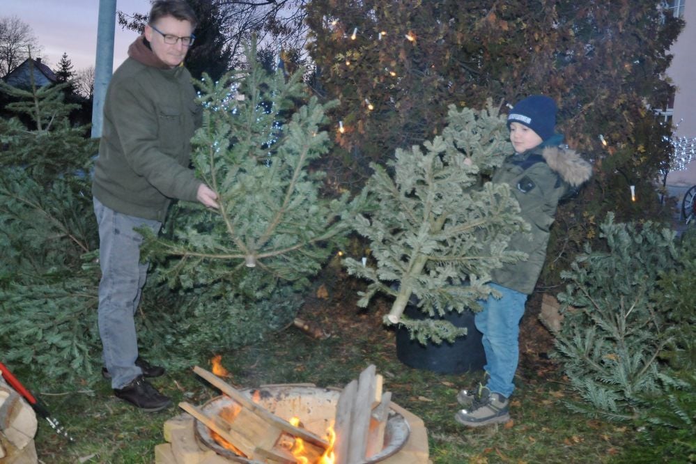 Sven Donnig (li.) und sein Sohn Felix (9) werfen die Bäume in Neugattersleben ins Feuer.