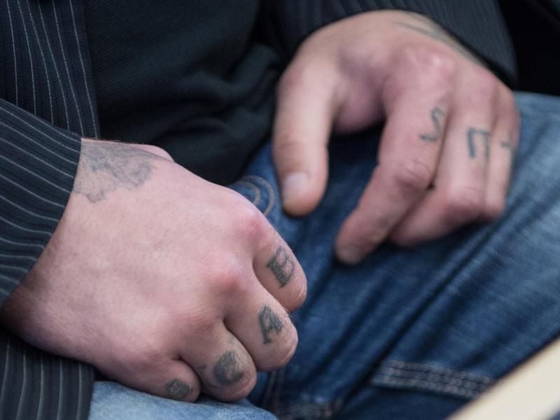 Die Szene-Tätowierung „ACAB” („All cops are bastards” - „Alle Bullen sind Schweine”) ist auf den Fingern des Angeklagten sichtbar. Der 28-Jährige soll einen Polizisten ermordet und einen anderen schwer verletzt haben. Foto: Boris Roessler