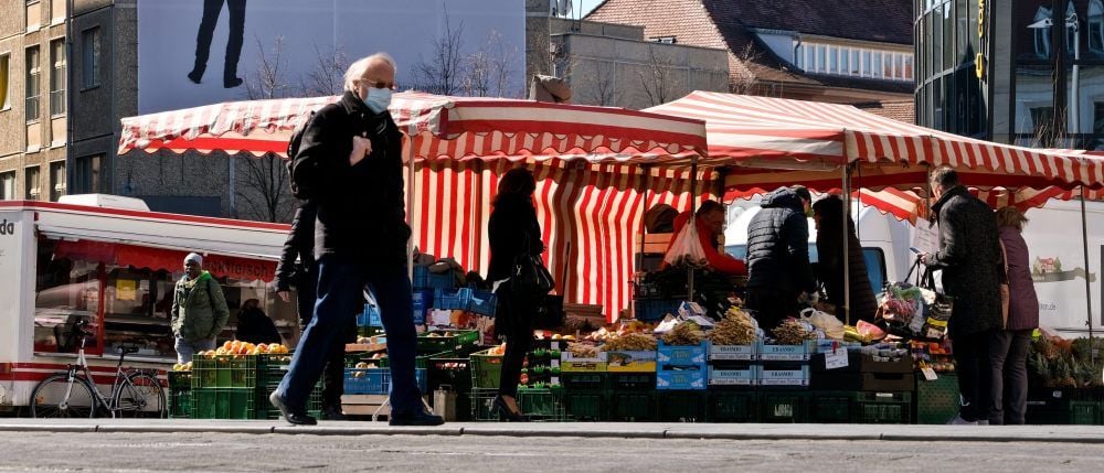 Gut geschützt über den Wochenmarkt: Manche Kunden tragen Mundschutz.