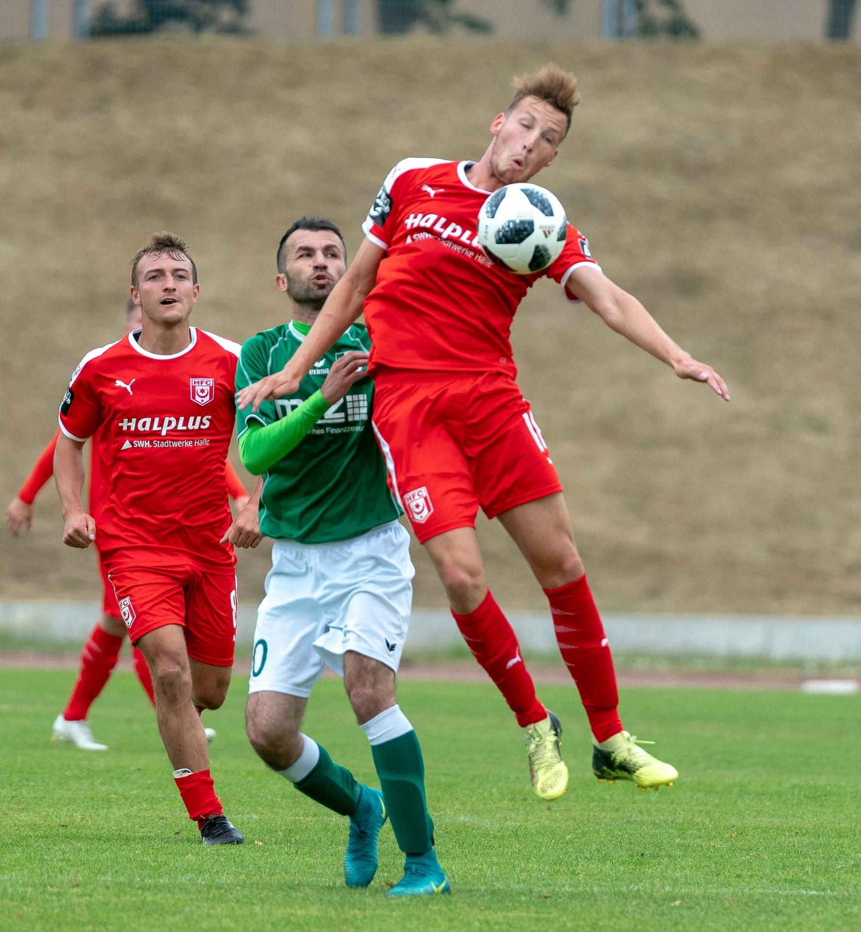 Mittelfeldspieler Martin Ludwig (r.) und Daniel Bohl (l.) gegen Halle-Neustadts Araz Dosky (M.) im Testspiel des HFC gegen den FC Halle-Neustadt.