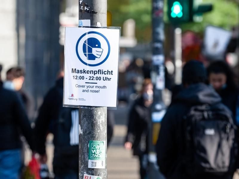 Ein Schild mit Hinweis über die Maskenpfilcht zu Beginn der Straße Steindamm im Stadtteil St.Georg. Foto: Markus Scholz/dpa