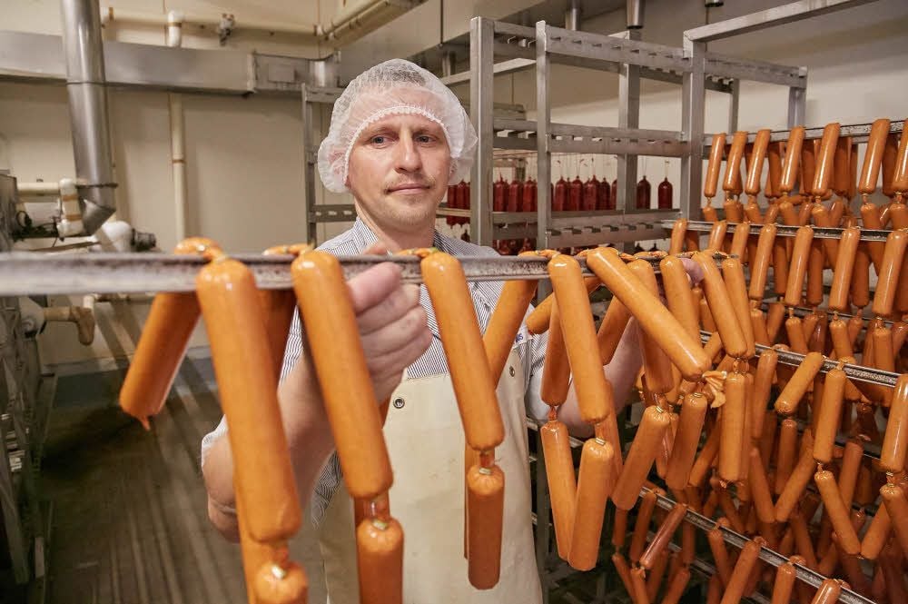 Fleischermeister Norman Ragus (links) bringt die Mettwurst indes in den Reiferaum.