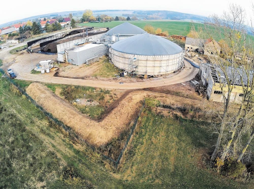 Hangabwärts zieht sich jetzt ein Wall ums Firmengelände. Das Leck am Gärrestebehälter (vorn) ist verschlossen, er kann wieder befüllt werden.