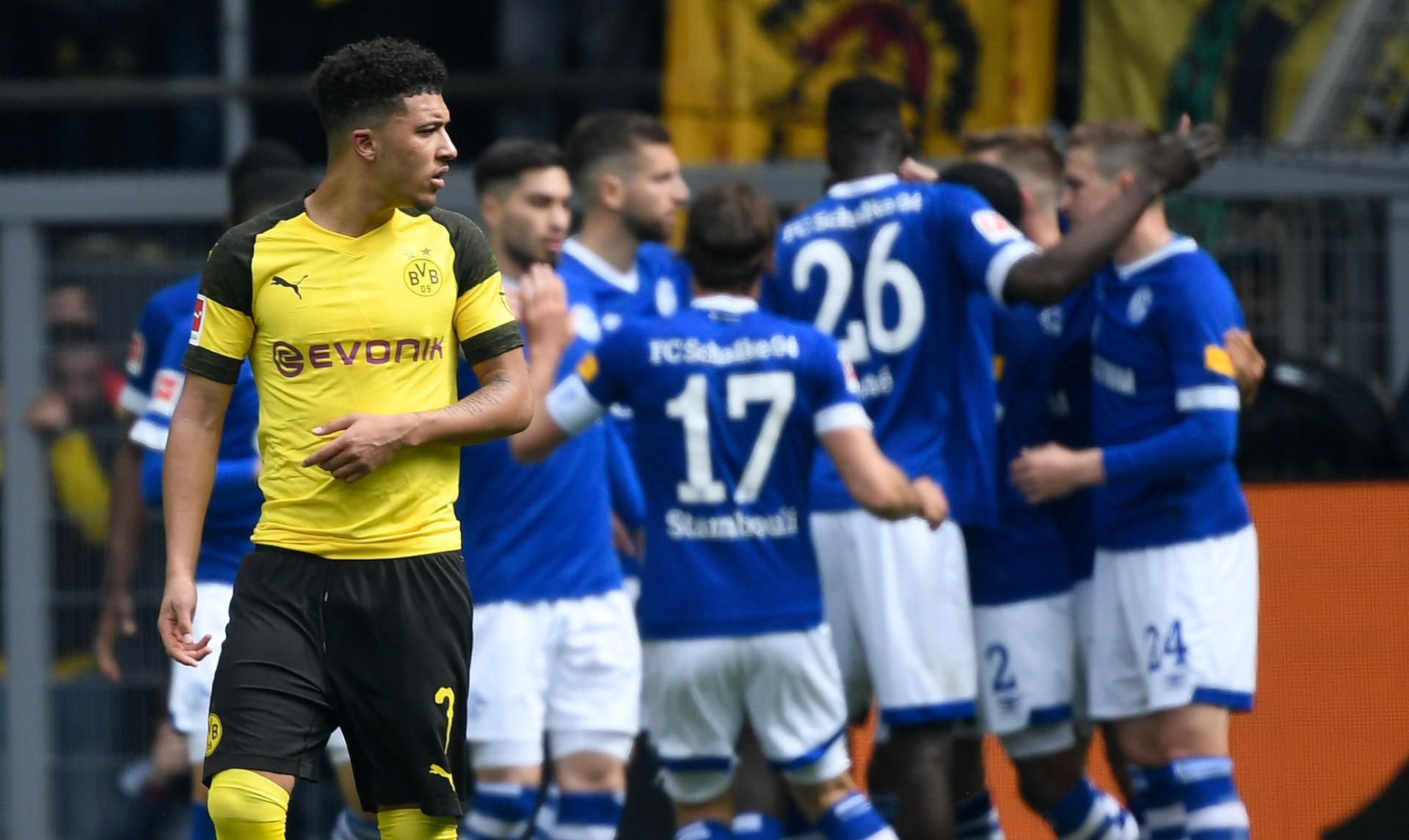Im Hintergrund jubeln die Schalker, während BVB-Profi Jadon Sancho sind abwendet.