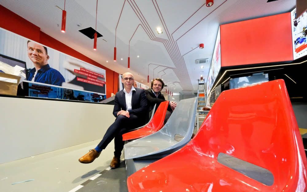 Andreas Völker (vorn) und Architekt Wolfgang Kreser sitzen auf Stühlen aus einer Tatra-Bahn. Die Sitze sind original und 40 Jahre alt.