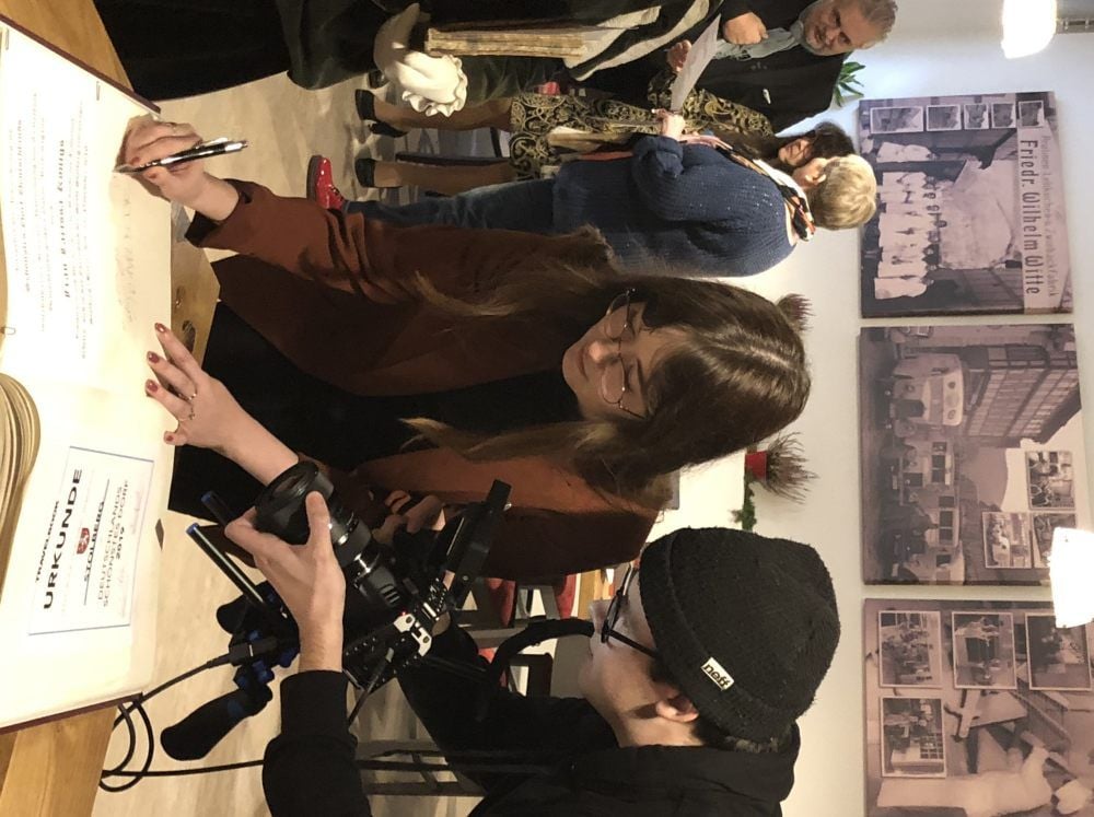 Auch das wird gefilmt. Larissa Königs trägt sich ins Goldene Buch der Stadt Stolberg ein.