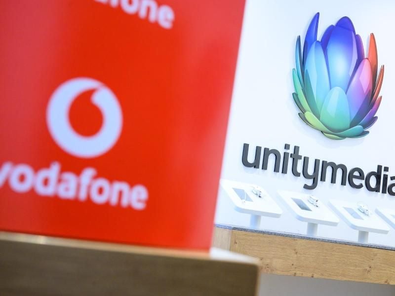 Eine Box mit dem Logo von Vodafone steht in einem Shop des Unternehmens vor einem Logo von Unitymedia. Foto: Sebastian Gollnow/dpa