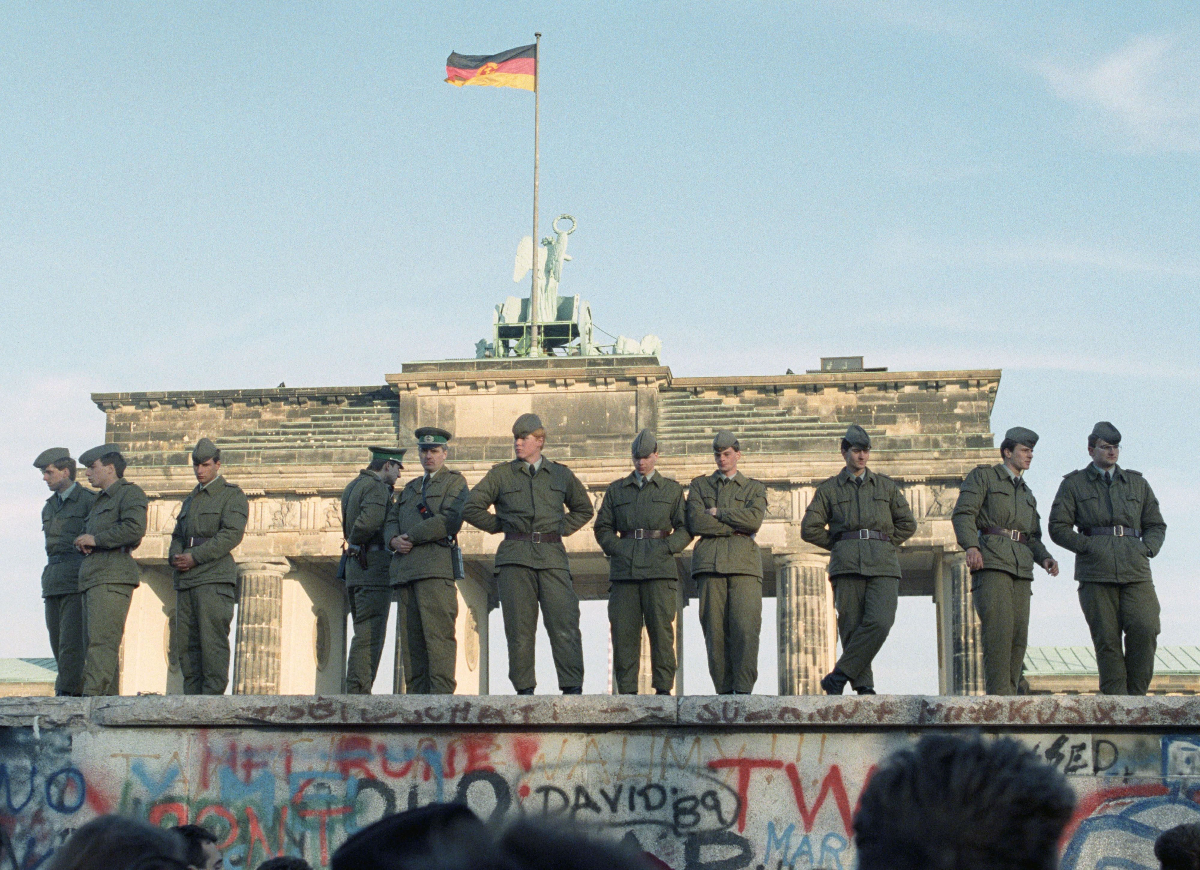 Blick von der Westberliner Seite auf Grenzsoldaten der DDR auf der Mauer am Brandenburger Tor am 11.11.1989.