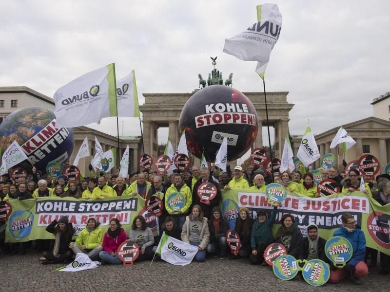 Mitglieder des Bundes für Umwelt und Naturschutz Deutschland (BUND) demonstrieren vor dem Brandenburger Tor für einen Ausstieg aus der Kohleförderung. Foto: Paul Zinken