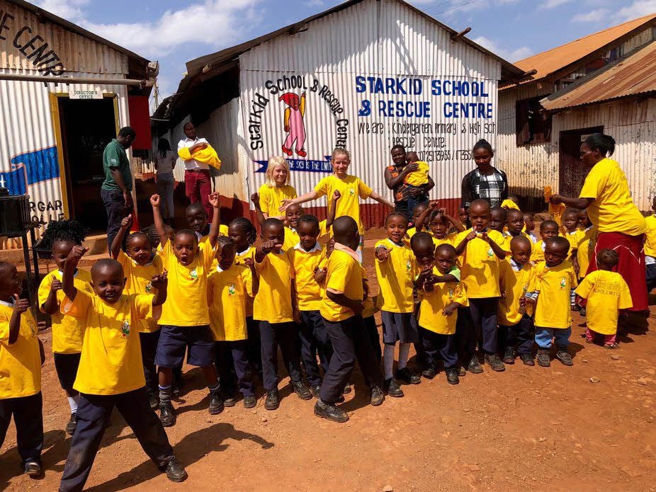 Raphael und Johanna (im Hintergrund) freuen sich gemeinsam mit den Waisenkindern der Starkid School Nairobi über die gelben T-Shirts.