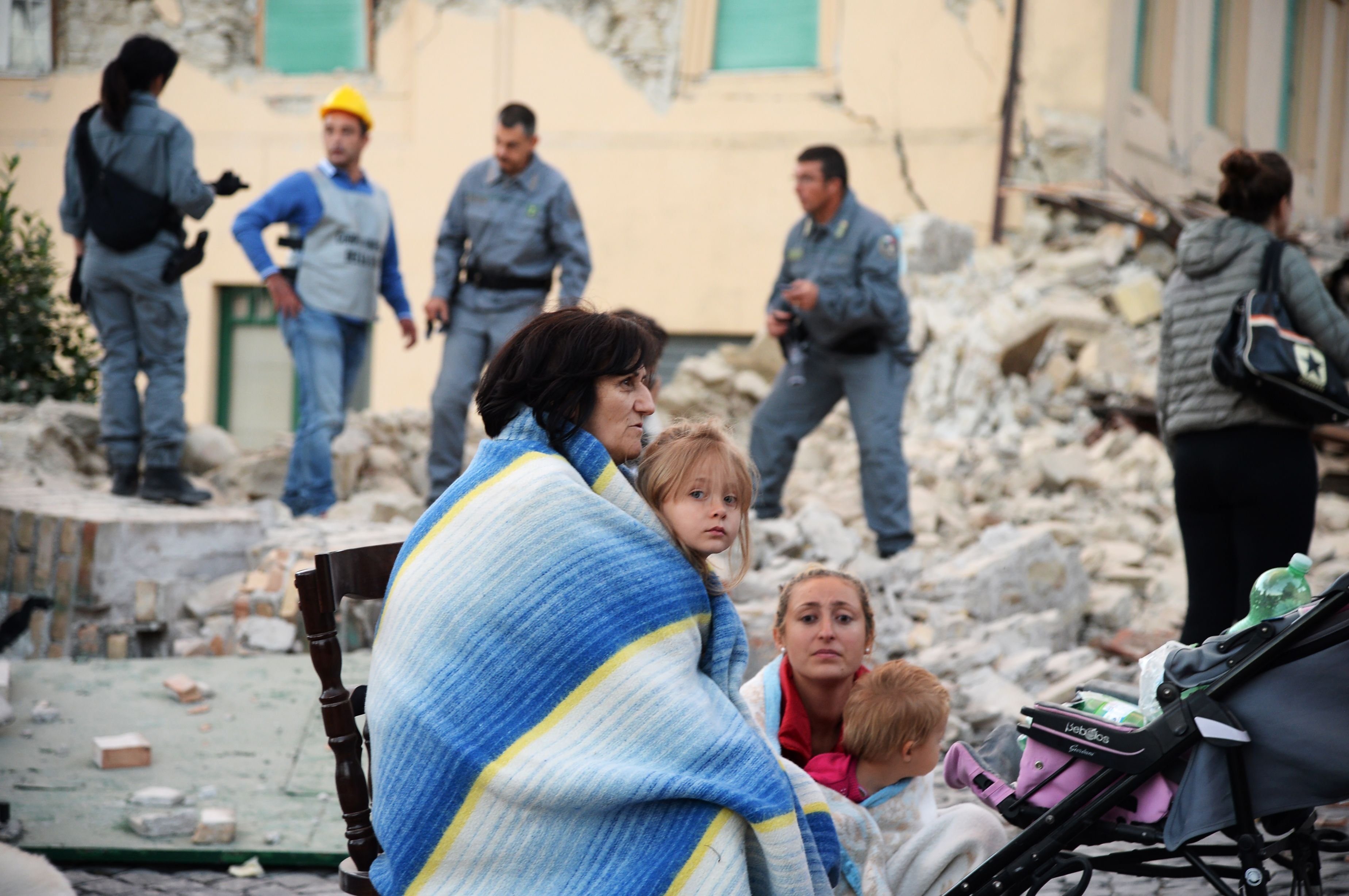 Familien harren in Amatrice vor ihren zerstörten Häusern aus.