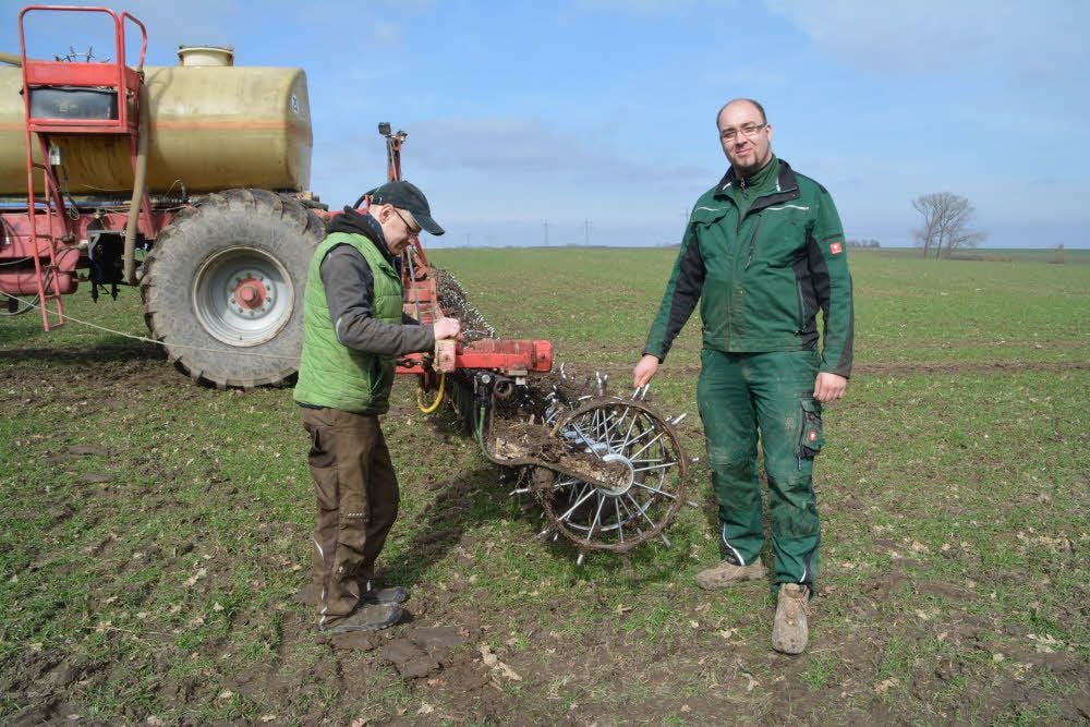 Stephan Frank (r.) und Mitarbeiter Gerd Steinke kontrollieren das Düngegerät nach der Fahrt übers Feld bei Priesen.