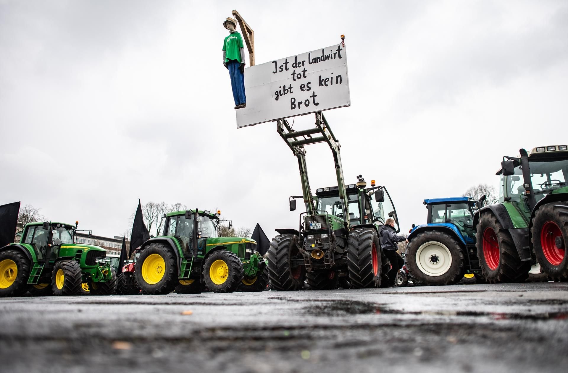 Eine Puppe hängt an einem Traktor und baumelt an einem Galgen mit dem Schild.