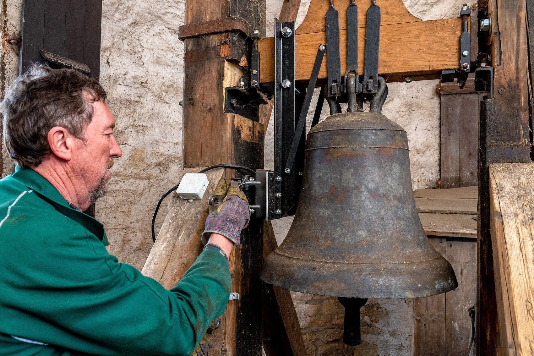 Frank John von der Firma Turmuhren & Glockentechnik Wende aus dem Burgenland montiert den Motor, der die Glocke zum Schwingen bringt.
